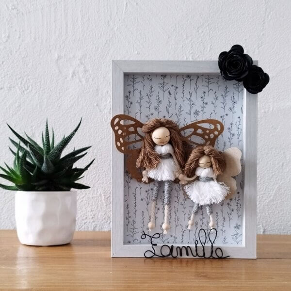 poupées macramé avec ailes en papier dans un cadre en médium
