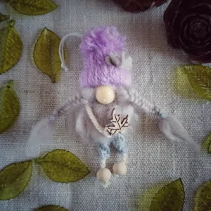 magnet avec bonnet en laine rose, barbe en laine cardée, nez en perle de bois, pantalon gris en macramé