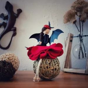 fée avec jupe en feutrine, aile de chauve-souris en papier et chapeau de gland rouge sur la tête