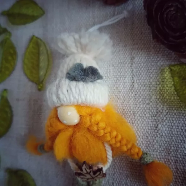 magnet avec bonnet en laine écru, barbe en laine cardée, nez en perle de bois, pantalon vert en macramé
