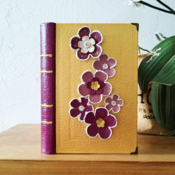 page de couverture d'un vieux livre upcyclé avec fleurs en carton