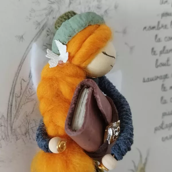 fée réalisée à la main, tenant un livre dans ses bras, jupe en chute de tissus et béret en cupule